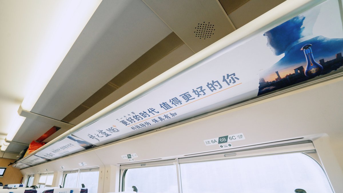 Luggage rack advertising panel above passenger windows on a high-speed railway train